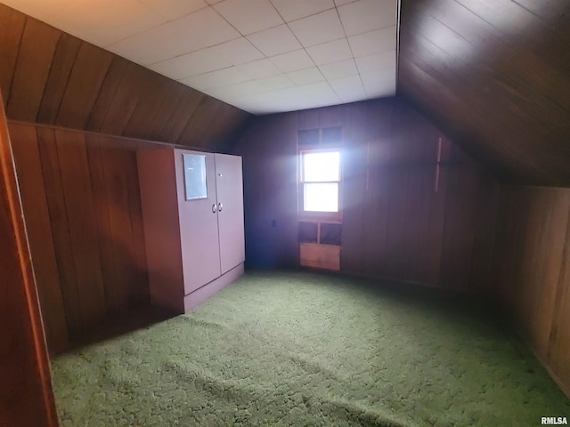 bonus room featuring carpet flooring, wood walls, and vaulted ceiling