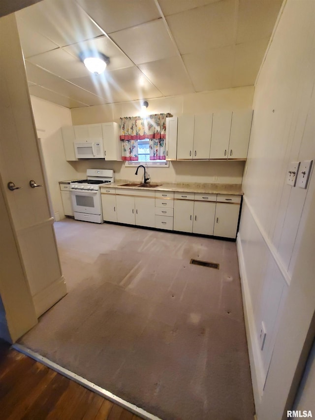 kitchen with white cabinets, light wood-type flooring, white appliances, and sink