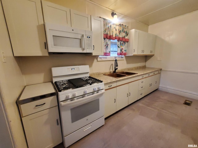 kitchen featuring white appliances, light colored carpet, white cabinetry, and sink