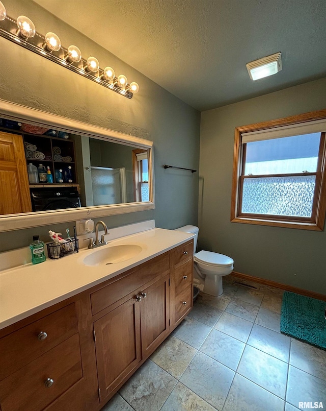 bathroom with tile patterned floors, vanity, toilet, and a textured ceiling