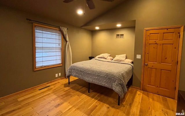 bedroom featuring light wood-type flooring, vaulted ceiling, and ceiling fan