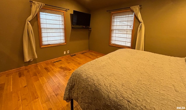 unfurnished bedroom with vaulted ceiling and hardwood / wood-style flooring