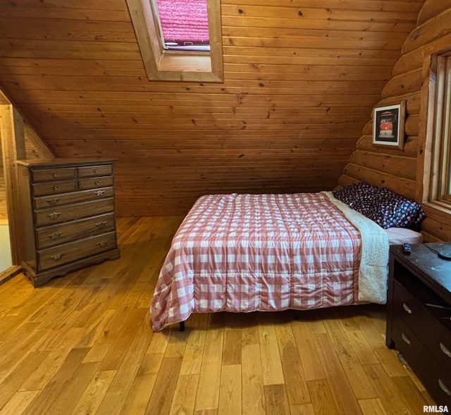 unfurnished bedroom featuring lofted ceiling with skylight, light hardwood / wood-style flooring, wood ceiling, and wooden walls