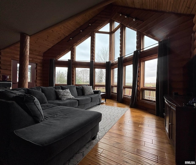 living room with wooden ceiling, high vaulted ceiling, light hardwood / wood-style flooring, and a healthy amount of sunlight