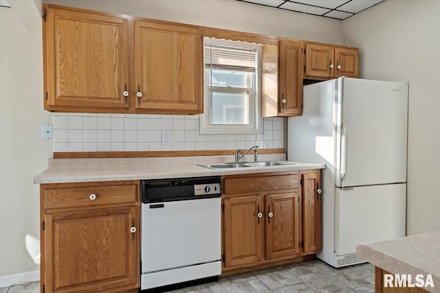 kitchen featuring backsplash, sink, and white appliances