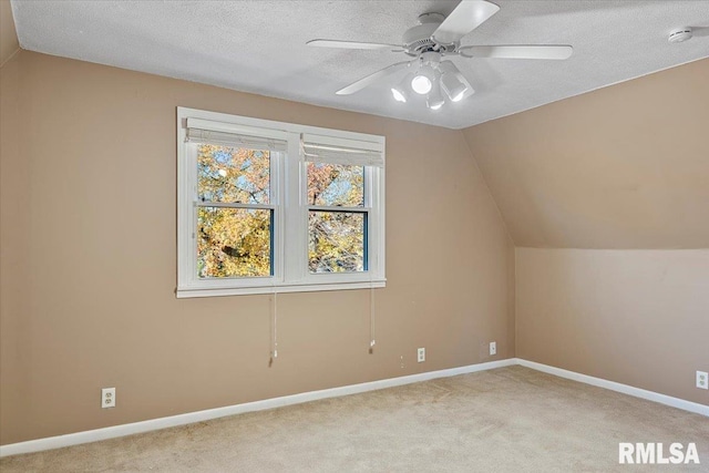 additional living space with ceiling fan, lofted ceiling, and a textured ceiling