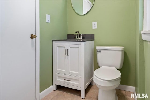 bathroom featuring tile patterned flooring, vanity, and toilet