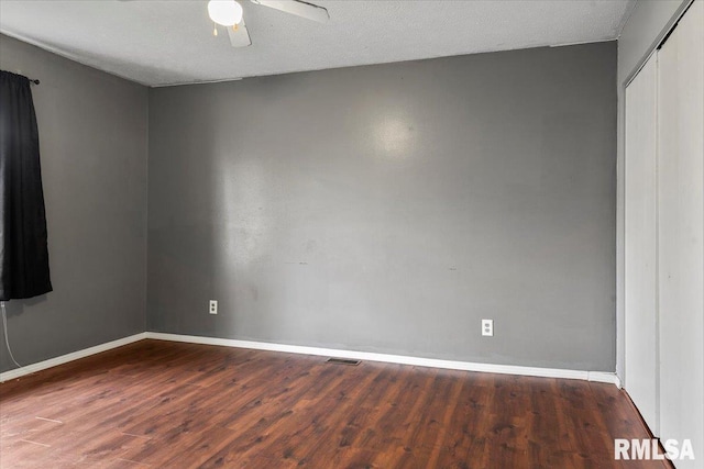 unfurnished room with dark hardwood / wood-style floors, ceiling fan, and a textured ceiling