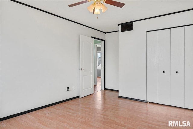 unfurnished bedroom with ceiling fan, a closet, and light wood-type flooring