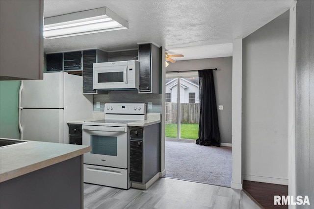 kitchen featuring ceiling fan, light hardwood / wood-style floors, white appliances, and a textured ceiling