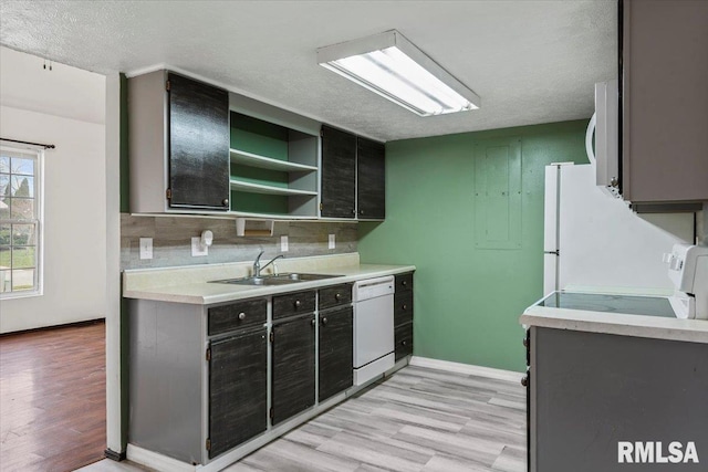 kitchen featuring a textured ceiling, light hardwood / wood-style floors, white appliances, and sink