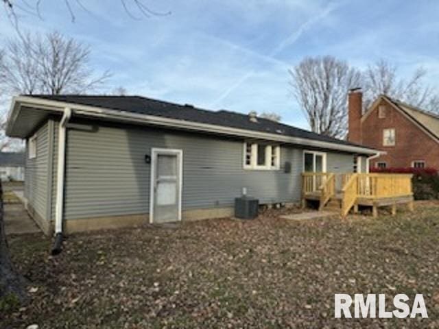 rear view of property with cooling unit and a wooden deck