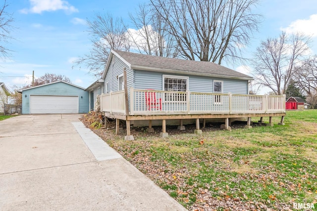 view of front of home with a wooden deck, a front lawn, an outdoor structure, and a garage