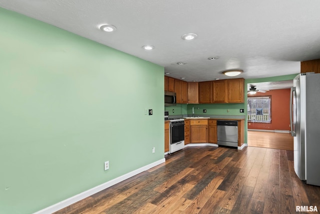 kitchen with dark wood-type flooring, sink, ceiling fan, a textured ceiling, and appliances with stainless steel finishes