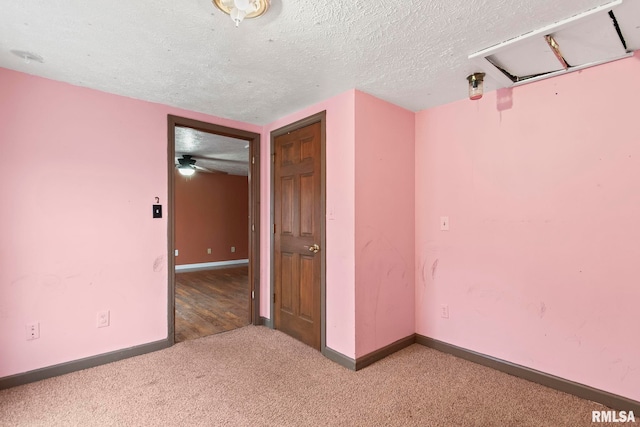 carpeted spare room featuring a textured ceiling and ceiling fan