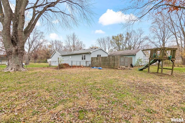 rear view of house featuring a playground and a lawn