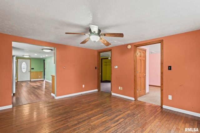 empty room with ceiling fan, dark hardwood / wood-style flooring, and a textured ceiling