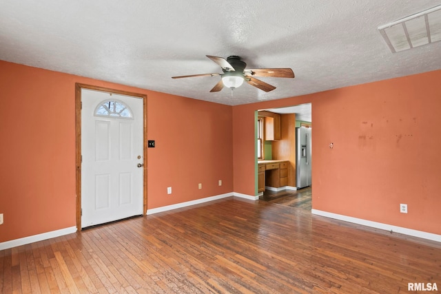 entrance foyer featuring a textured ceiling, ceiling fan, and dark hardwood / wood-style floors