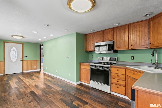 kitchen with a textured ceiling, sink, white range with gas stovetop, and dark hardwood / wood-style floors