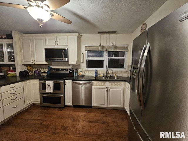 kitchen featuring dark hardwood / wood-style flooring, tasteful backsplash, stainless steel appliances, sink, and white cabinetry