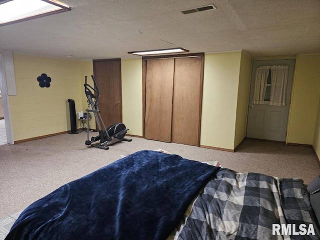 bedroom with a textured ceiling, light carpet, and a closet