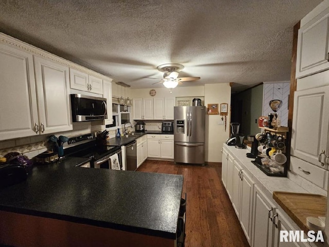 kitchen with white cabinets, sink, dark hardwood / wood-style floors, a textured ceiling, and appliances with stainless steel finishes