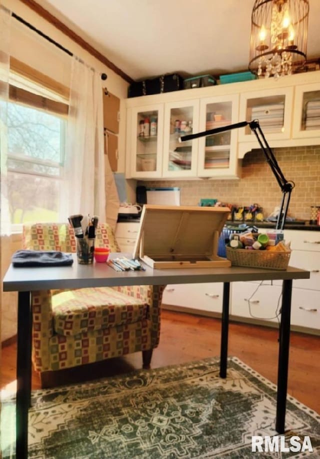 miscellaneous room with hardwood / wood-style floors and an inviting chandelier