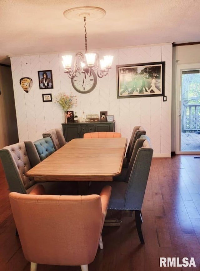 dining space with dark wood-type flooring and an inviting chandelier