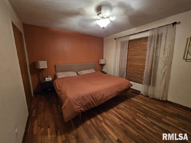 bedroom with ceiling fan and dark wood-type flooring