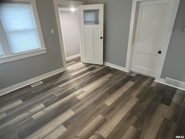 unfurnished room featuring dark wood-type flooring