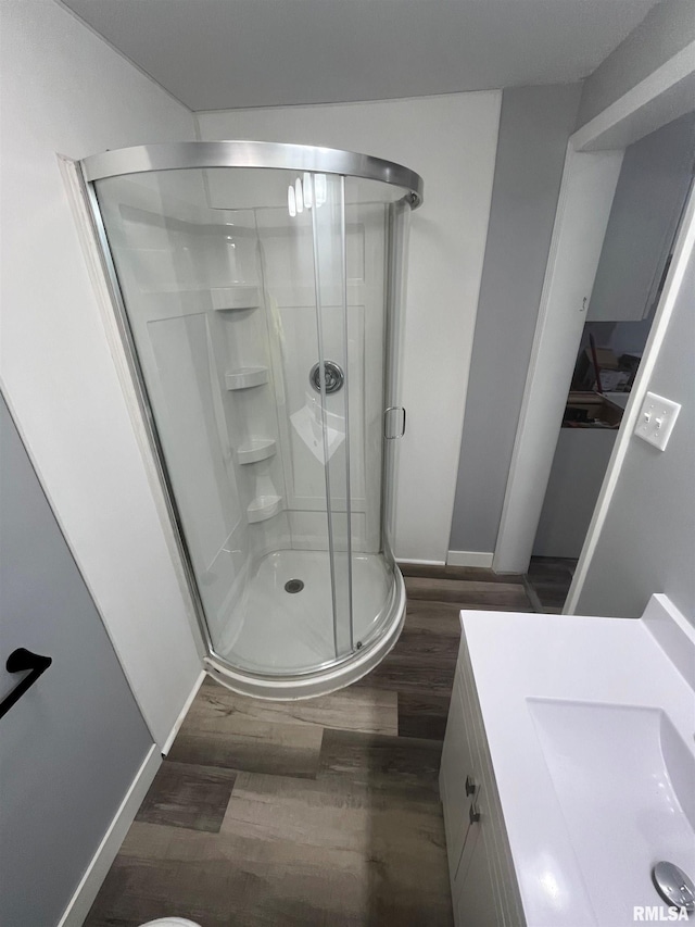 bathroom with wood-type flooring, vanity, and walk in shower