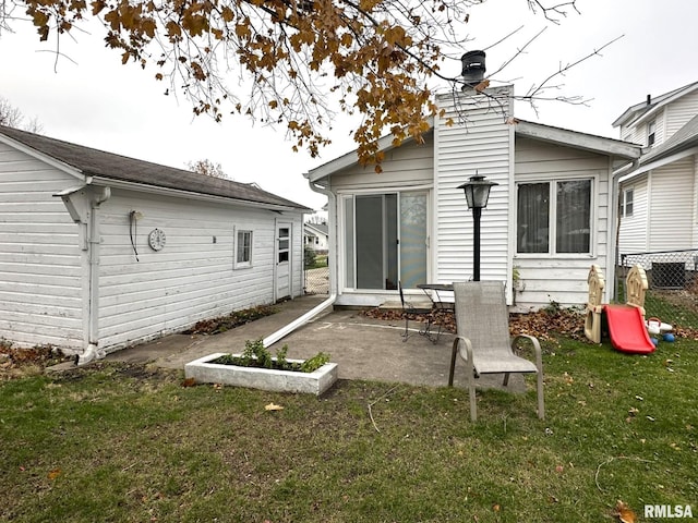 back of property featuring a lawn and a patio area