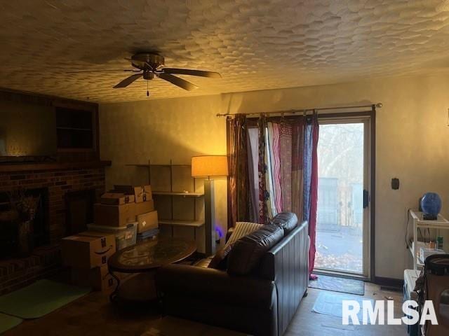 living room featuring ceiling fan and a fireplace