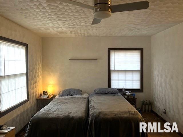 bedroom featuring ceiling fan and a textured ceiling