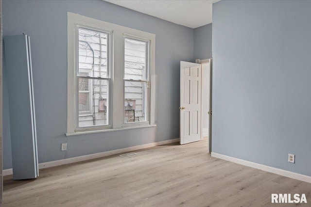 spare room with light wood-type flooring