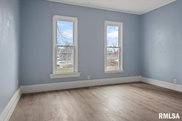 spare room with crown molding and light hardwood / wood-style flooring