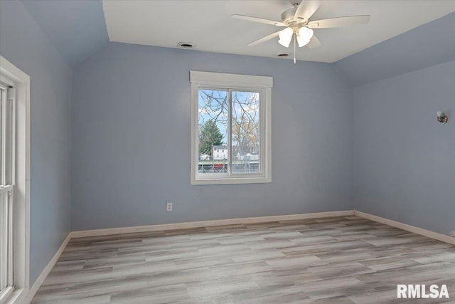 spare room with ceiling fan, light wood-type flooring, and vaulted ceiling