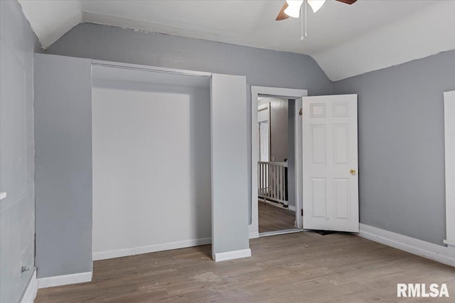 unfurnished bedroom featuring hardwood / wood-style floors, ceiling fan, a closet, and vaulted ceiling