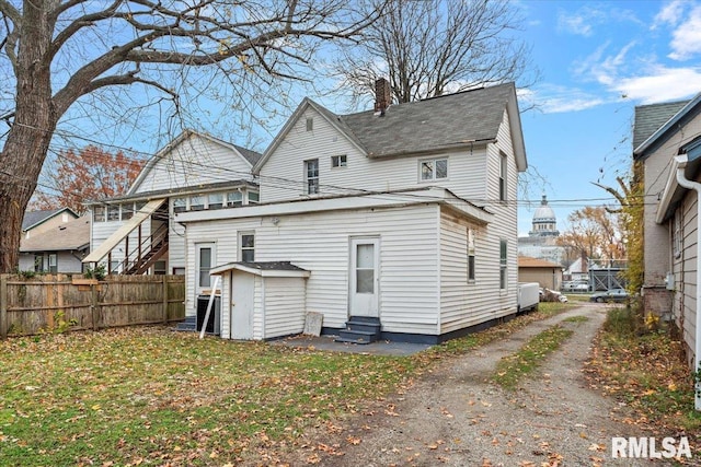 back of house featuring a yard and a storage shed