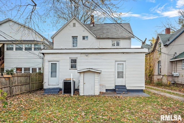 back of house with central AC and a lawn