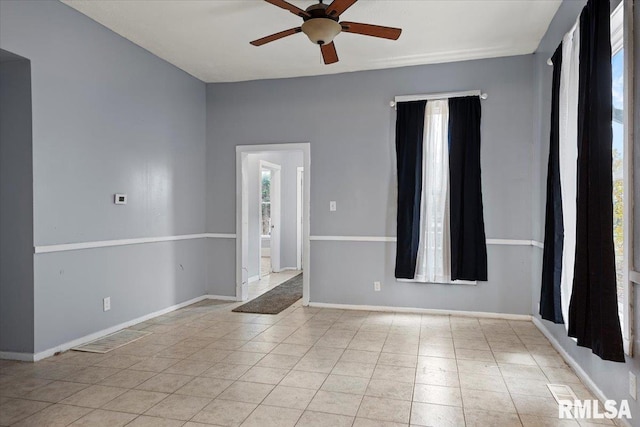 spare room with ceiling fan and light tile patterned flooring