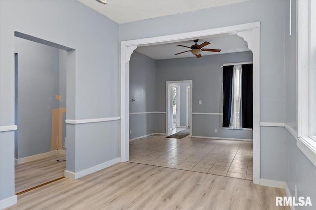 empty room featuring ceiling fan, plenty of natural light, and light wood-type flooring