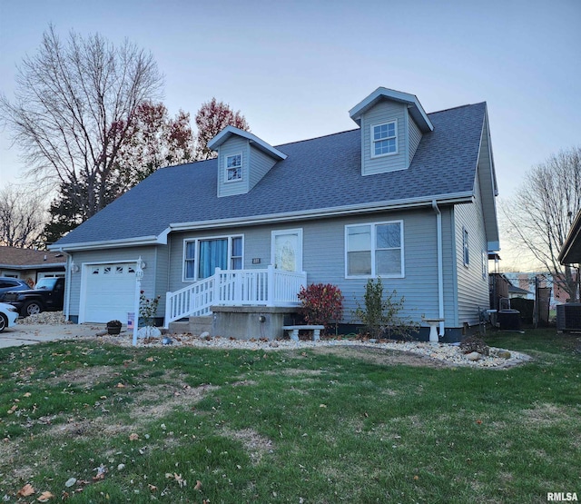 cape cod-style house with central air condition unit, a front lawn, and a garage