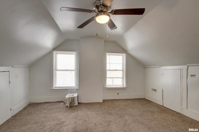 additional living space featuring ceiling fan, light colored carpet, and vaulted ceiling