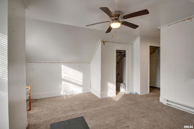 interior space featuring vaulted ceiling, light colored carpet, a baseboard radiator, and ceiling fan