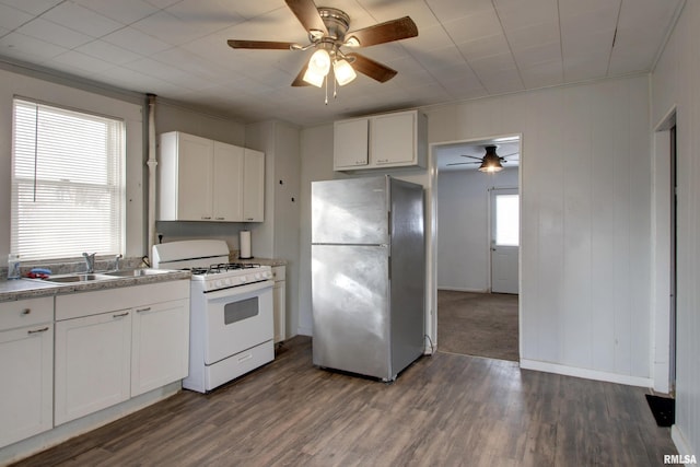 kitchen featuring dark wood-type flooring, white cabinets, sink, stainless steel fridge, and white gas range