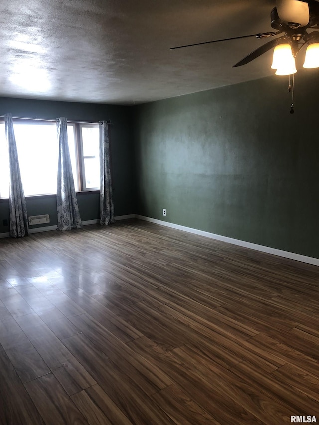 unfurnished room featuring dark wood-type flooring and ceiling fan