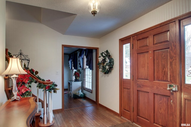 entryway with wood-type flooring and a textured ceiling