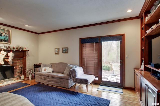 living room featuring light hardwood / wood-style floors, crown molding, and a brick fireplace