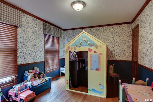 interior space with hardwood / wood-style flooring, crown molding, and a textured ceiling